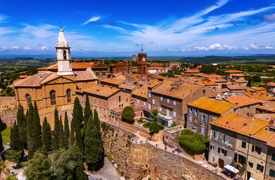 © monticellllo - stock.adobe.com Luftaufnahme einer italienischen Stadt mit Kirche und Zypressen.