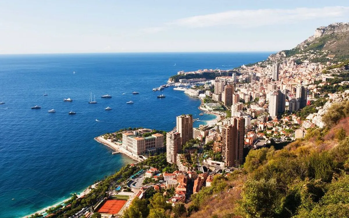 Blick auf Monaco mit Meer, Bergen, Stadt, Hafen und Yachten.