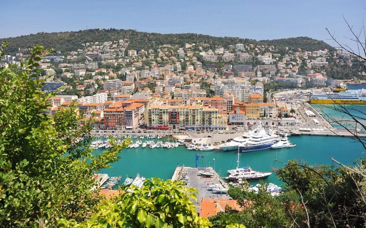 Stadtansicht von Nizza mit Hafen, Booten und mediterranen Gebäuden.