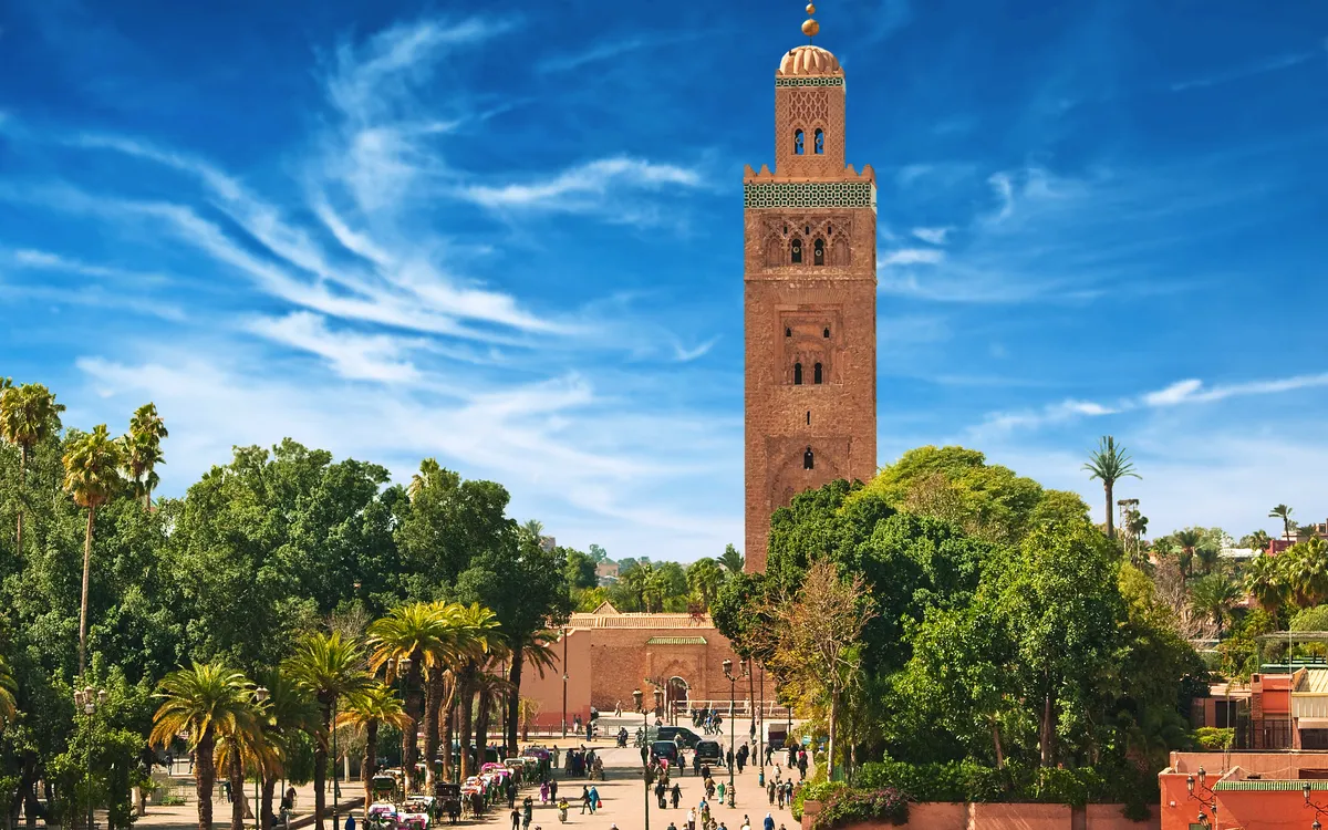 Hoher Turm inmitten von grünen Bäumen unter blauem Himmel.
