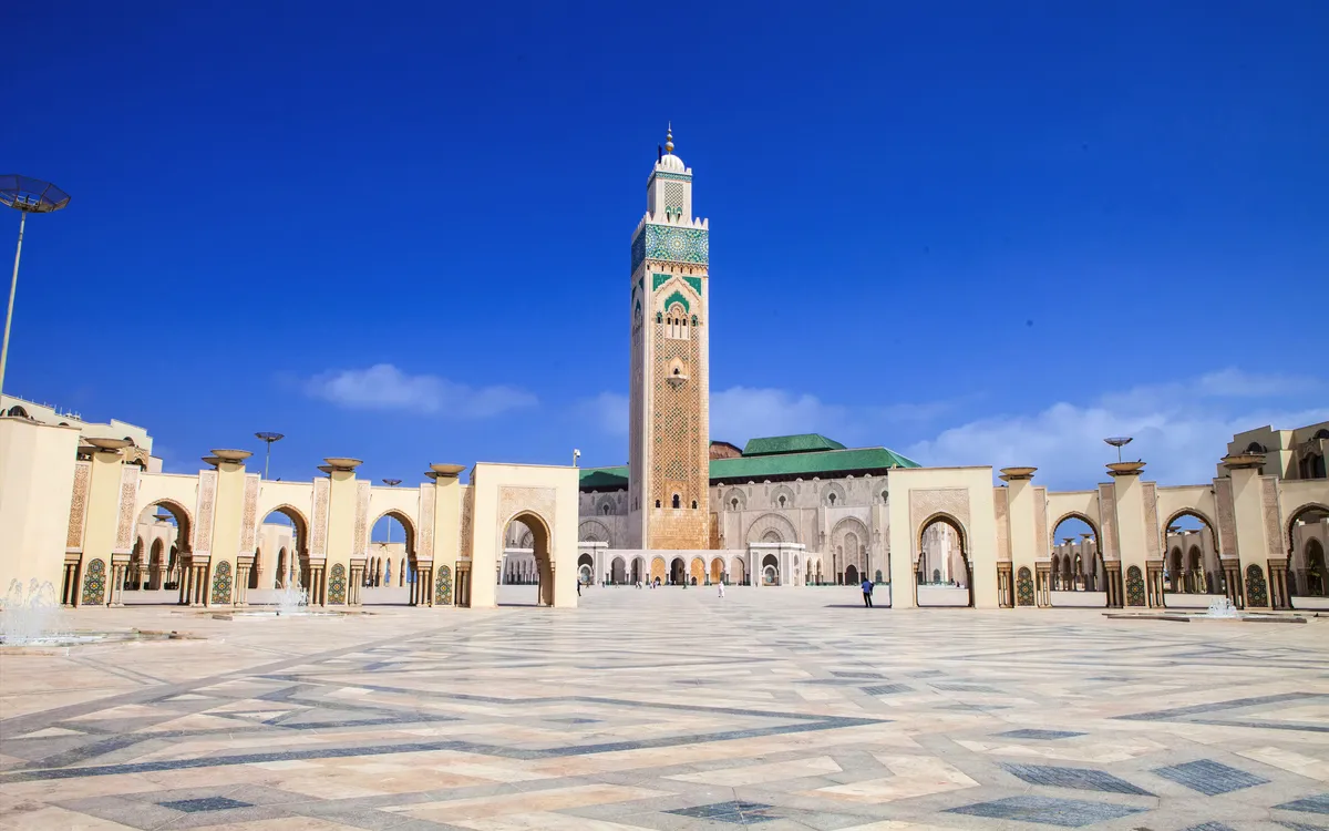 Moschee mit großem Minarett und offenem Platz bei klarem Himmel