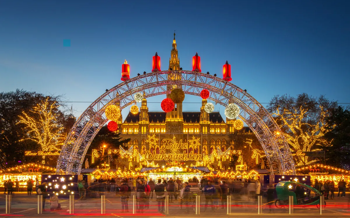 Christkindlmarkt am Rathausplatz in Wien, beleuchtete Weihnachtsdekoration und Besucher.