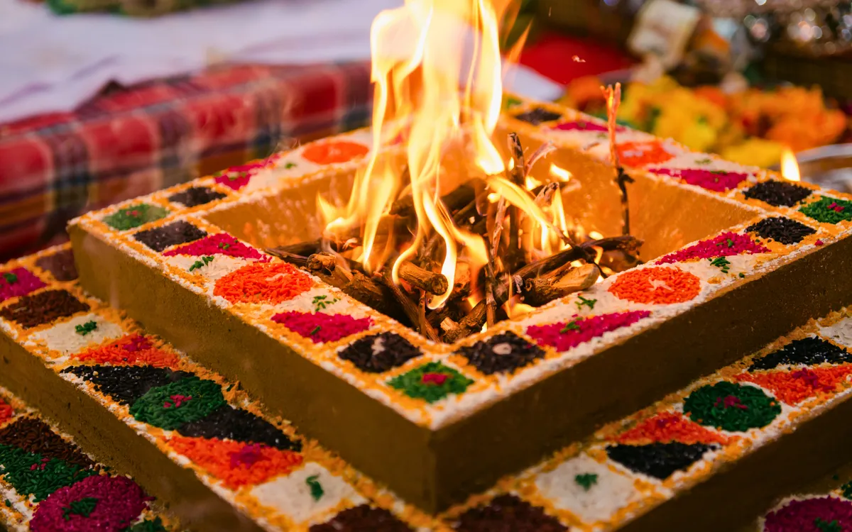 Feuerzeremonie mit brennendem Holz in dekoriertem Altar während Pooja.
