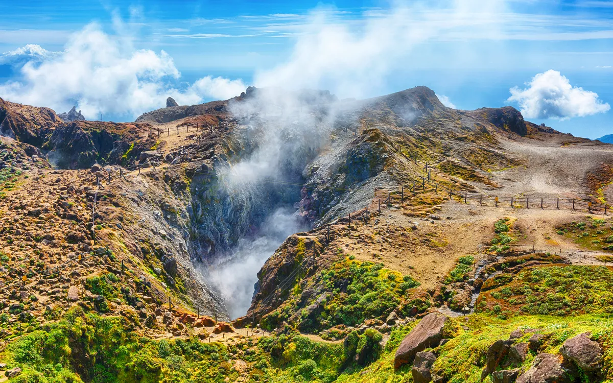 Vulkanlandschaft auf Basse-Terre in Guadeloupe mit rauchendem Vulkan Soufrière im Hintergrund.
