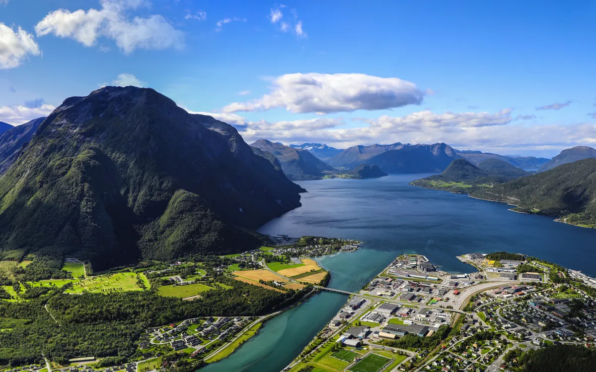 Luftaufnahme von Bergen, Tal und Fjord bei klarem Himmel.