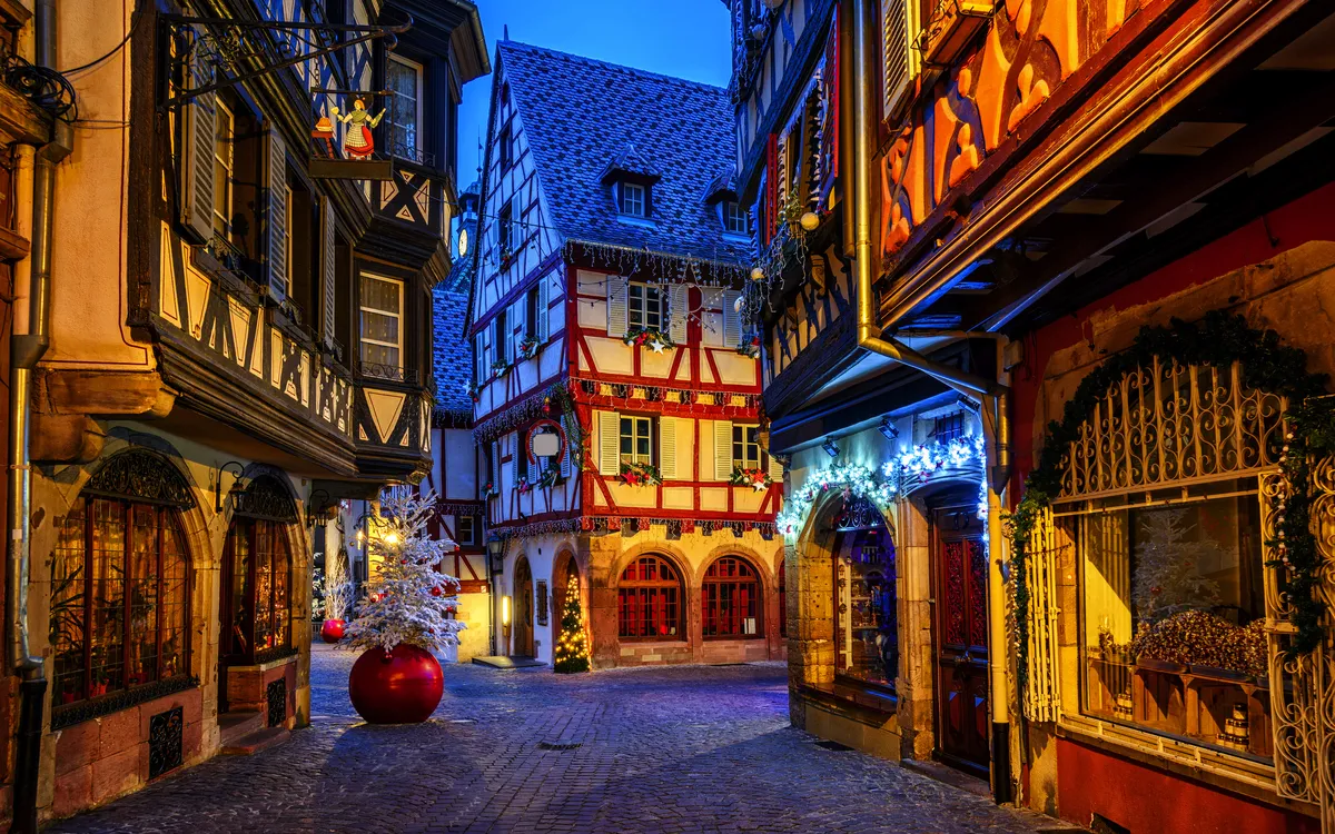 Verschneite Fachwerkhäuser in einer abendlichen Altstadtgasse.