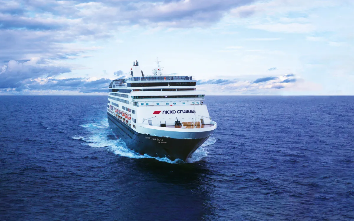 Kreuzfahrtschiff auf offenem Meer unter bewölktem Himmel.