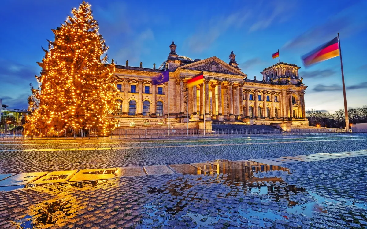 Weihnachtsbaum und beleuchteter Reichstag bei Nacht, Berlin.