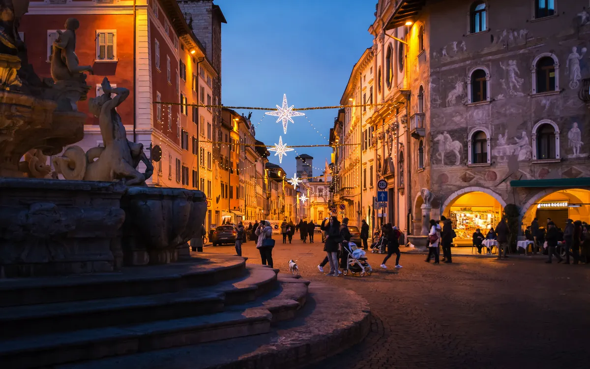 Trient im Winter, mit weihnachtlicher Beleuchtung in der Altstadt am Abend.