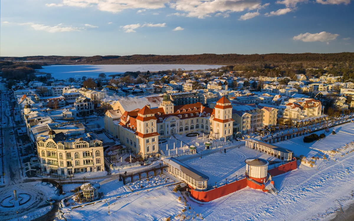 Kurhaus von Binz an der winterlichen Ostseeküste, umgeben von Schnee und Küste.