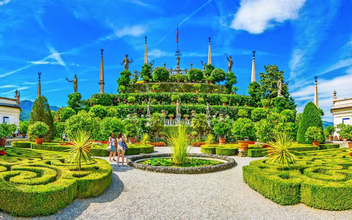 Terrassenförmiger italienischer Garten mit Statuen und kunstvoll geschnittenen Hecken.