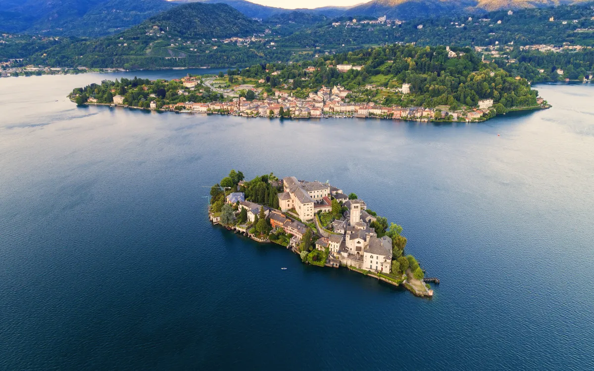 Luftaufnahme einer kleinen Insel mit historischen Gebäuden im See.