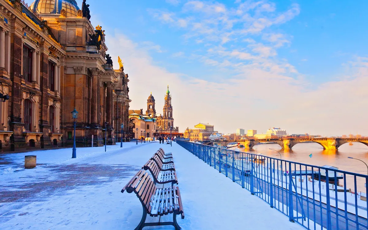 Verschneite Uferpromenade in Dresden mit Blick auf die historische Altstadt.