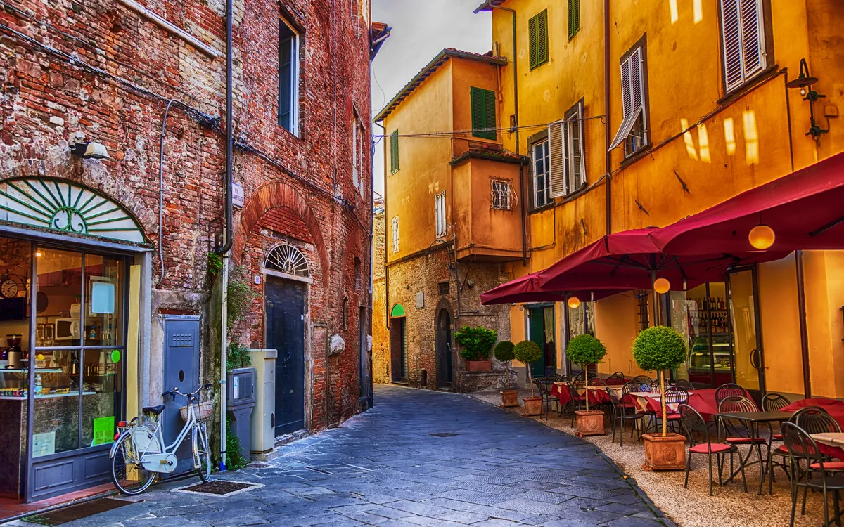 Schmale Gasse mit Café in historischer europäischer Altstadt.