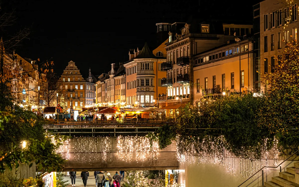 Nächtliche Stadtansicht mit beleuchteten Gebäuden und festlicher Dekoration.