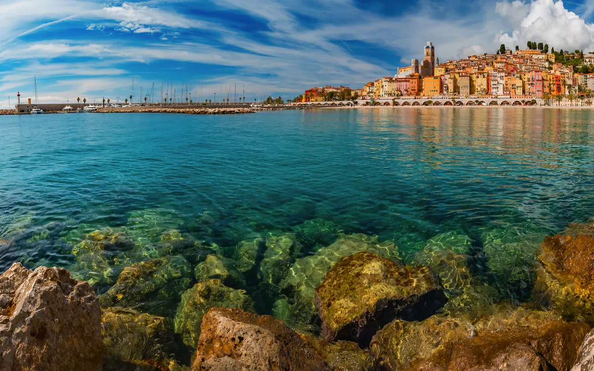 Küstenstadt am Meer mit bunten Häusern und klarem Wasser.