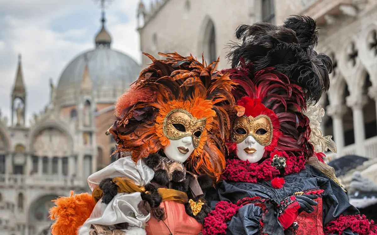 Personen in bunten venezianischen Masken beim Karneval in Venedig, Italien.