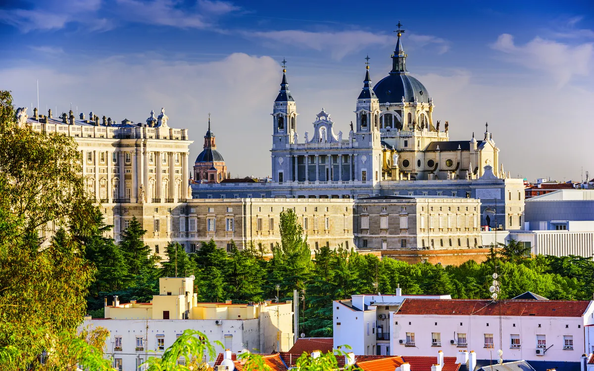 Panoramablick auf den Königspalast und die Almudena-Kathedrale in Madrid bei blauem Himmel.