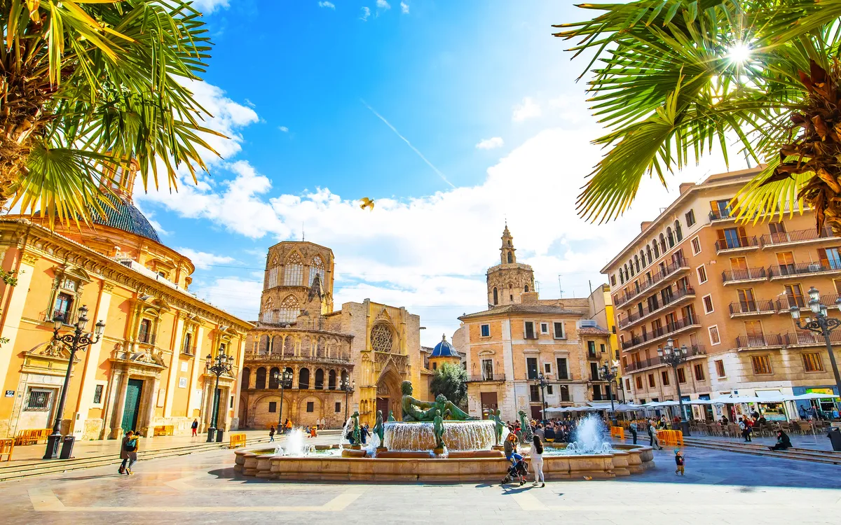 Plaza de la Reina in Valencia mit Kathedrale und Palmen bei Sonnenschein