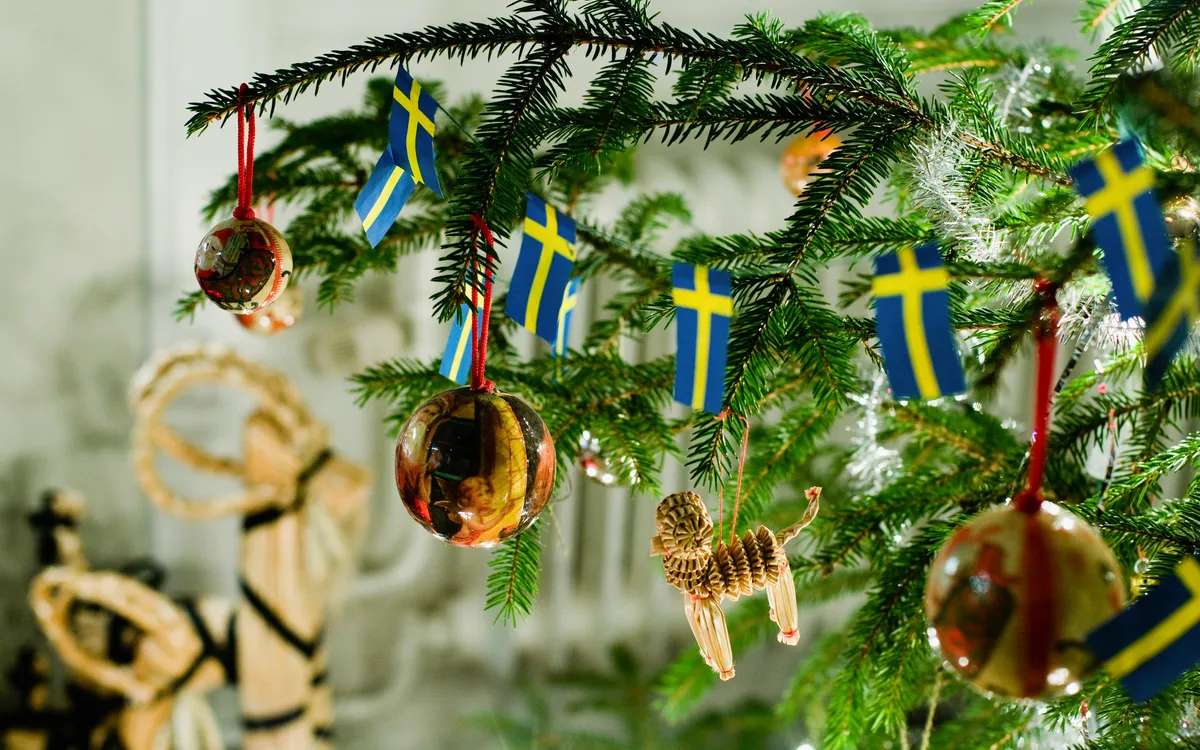 Traditionell geschmückter Weihnachtsbaum mit schwedischen Fahnen – Weihnachten in Schweden