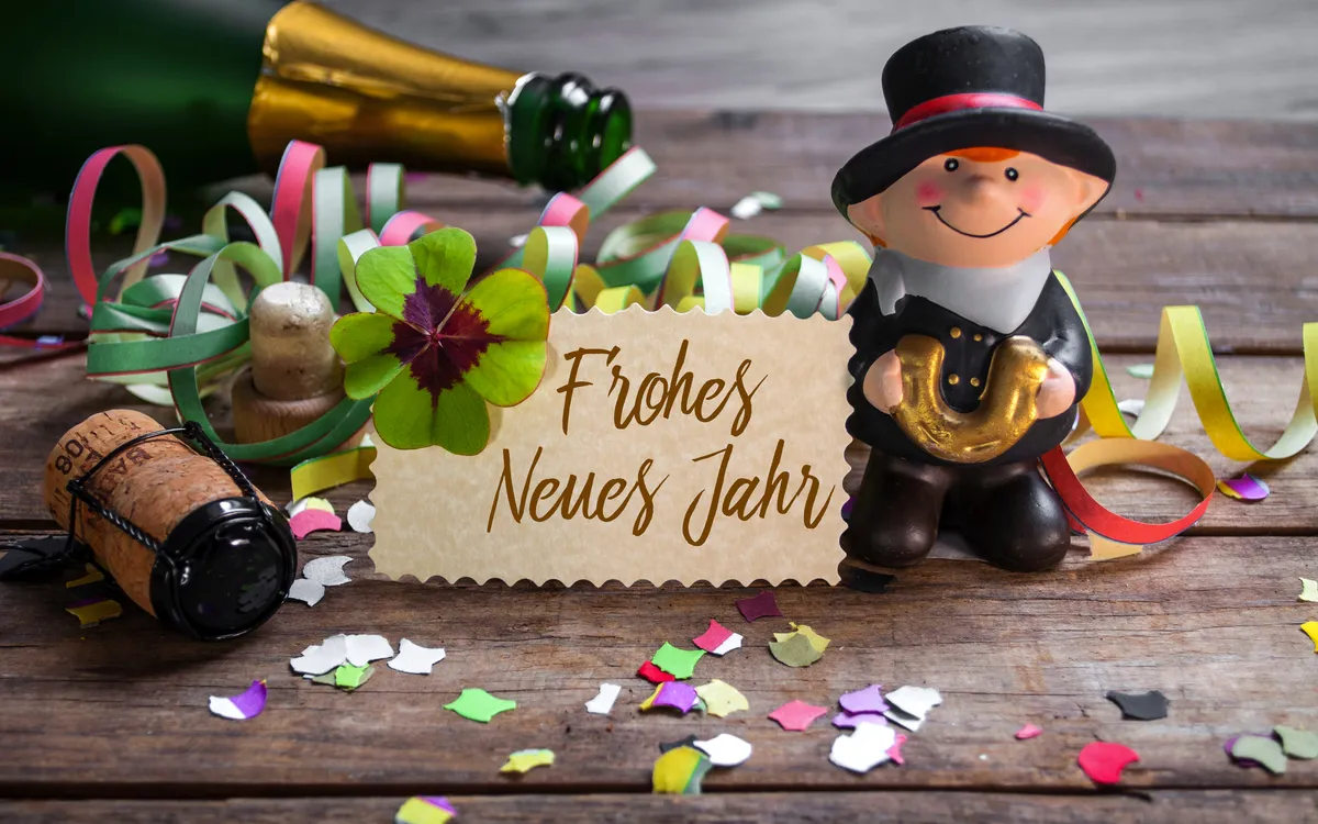 Silvesterkarte mit Schornsteinfeger, Kleeblatt, Konfetti, Sektflasche und Frohes Neues Jahr