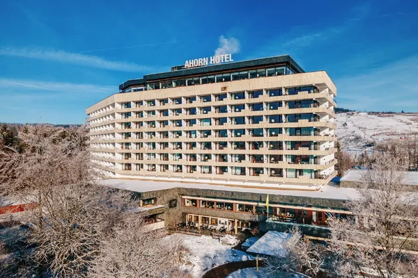 Ahorn-Harz-Hotel in Braunlage im Winter, Eingang und verschneite Umgebung.
