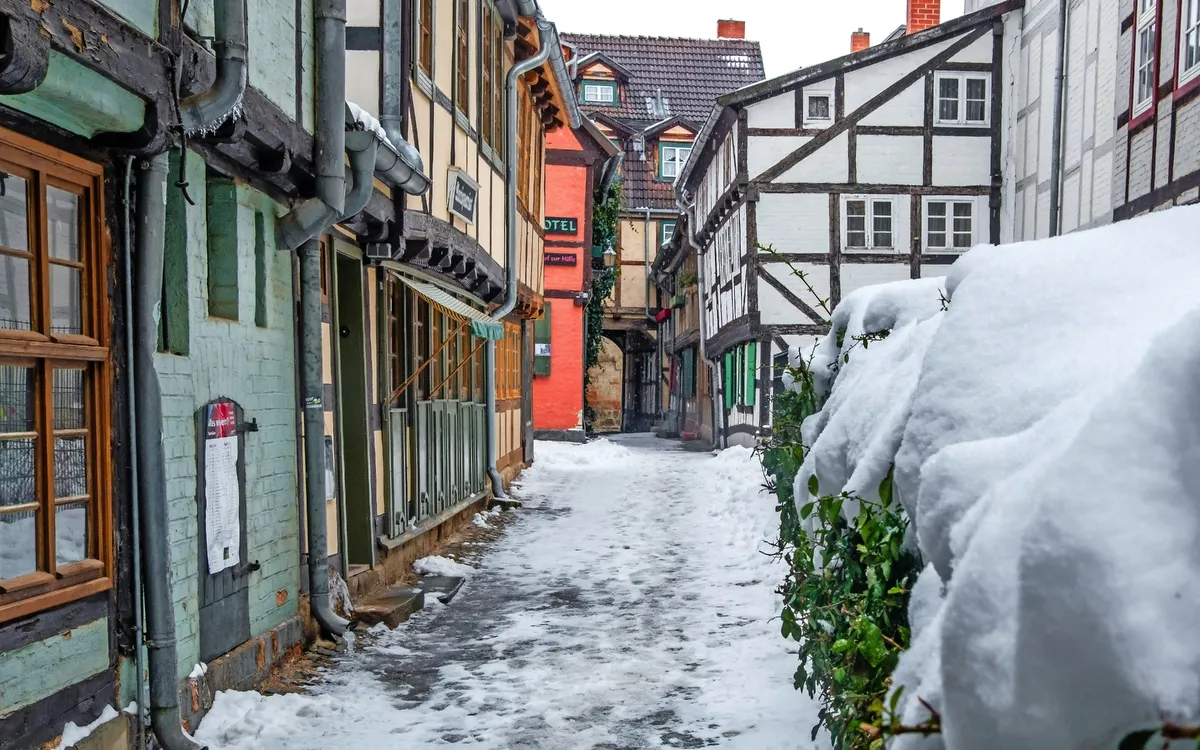 Verschneite Altstadtgasse mit Fachwerkhäusern.
