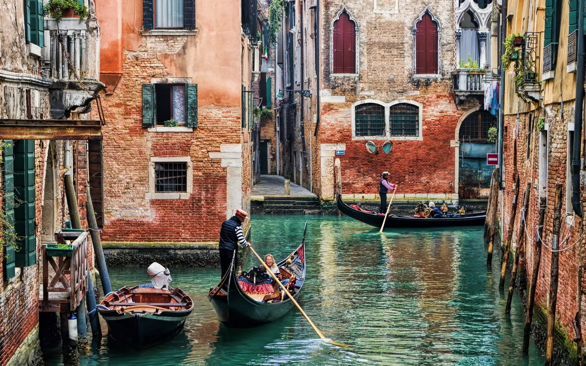 Gondeln in einem venezianischen Kanal zwischen alten Gebäuden