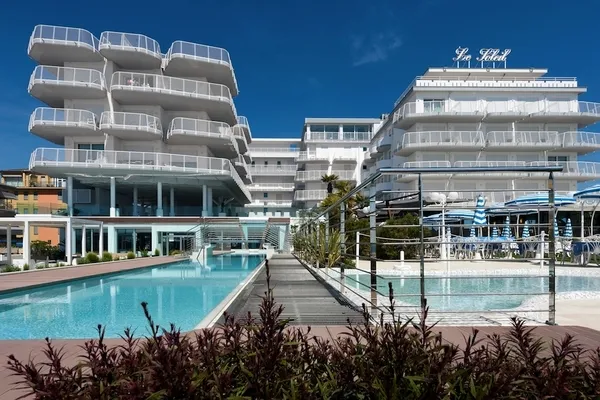 Hotel mit modernen Balkonen und Swimmingpool im Vordergrund.