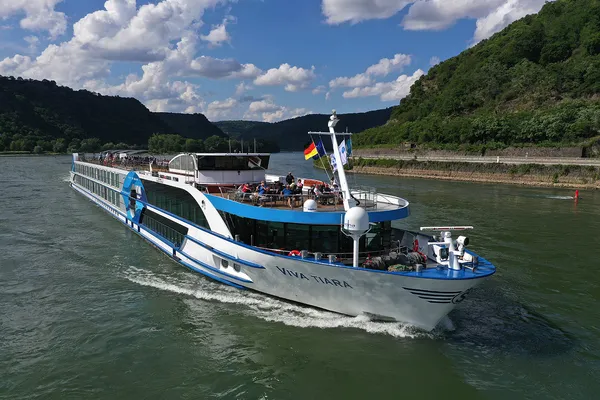 Flusskreuzfahrtschiff VIVA TIARA auf einem Fluss zwischen bewaldeten Hügeln.