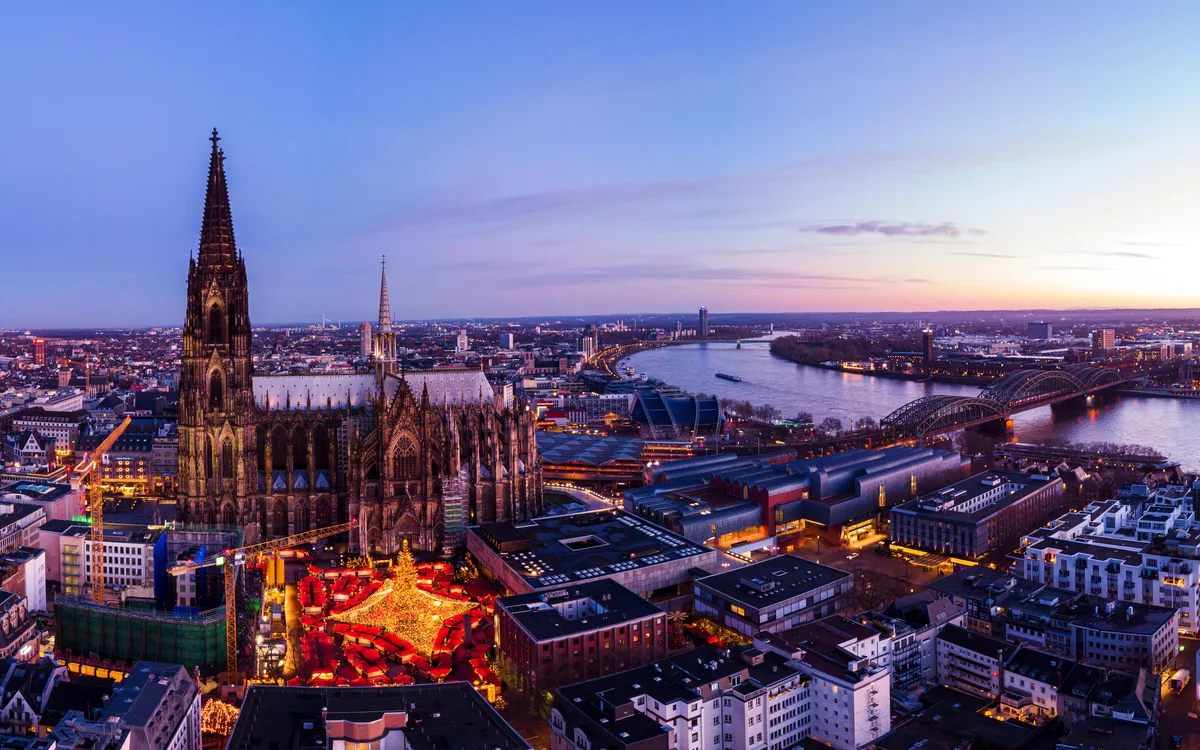 Kölner Dom und Stadt landschaft bei Sonnenuntergang, mit Rhein und Hohenzollernbrücke.