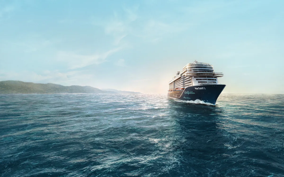 Kreuzfahrtschiff Mein Schiff 2 auf offener See unter blauem Himmel.