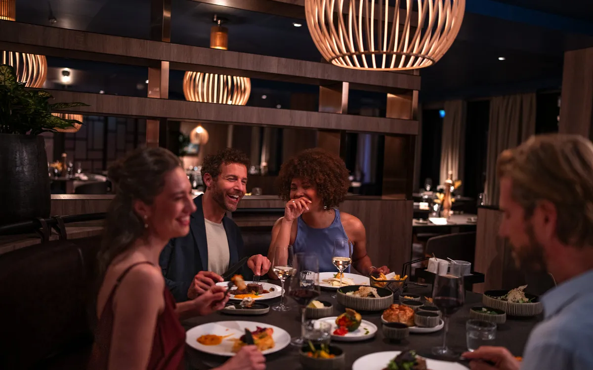 Vier Personen essen gemeinsam in einem schicken Restaurant.