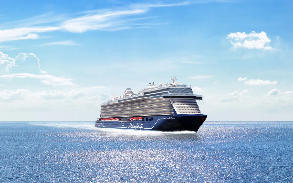 Kreuzfahrtschiff auf offenem Meer unter blauem Himmel.