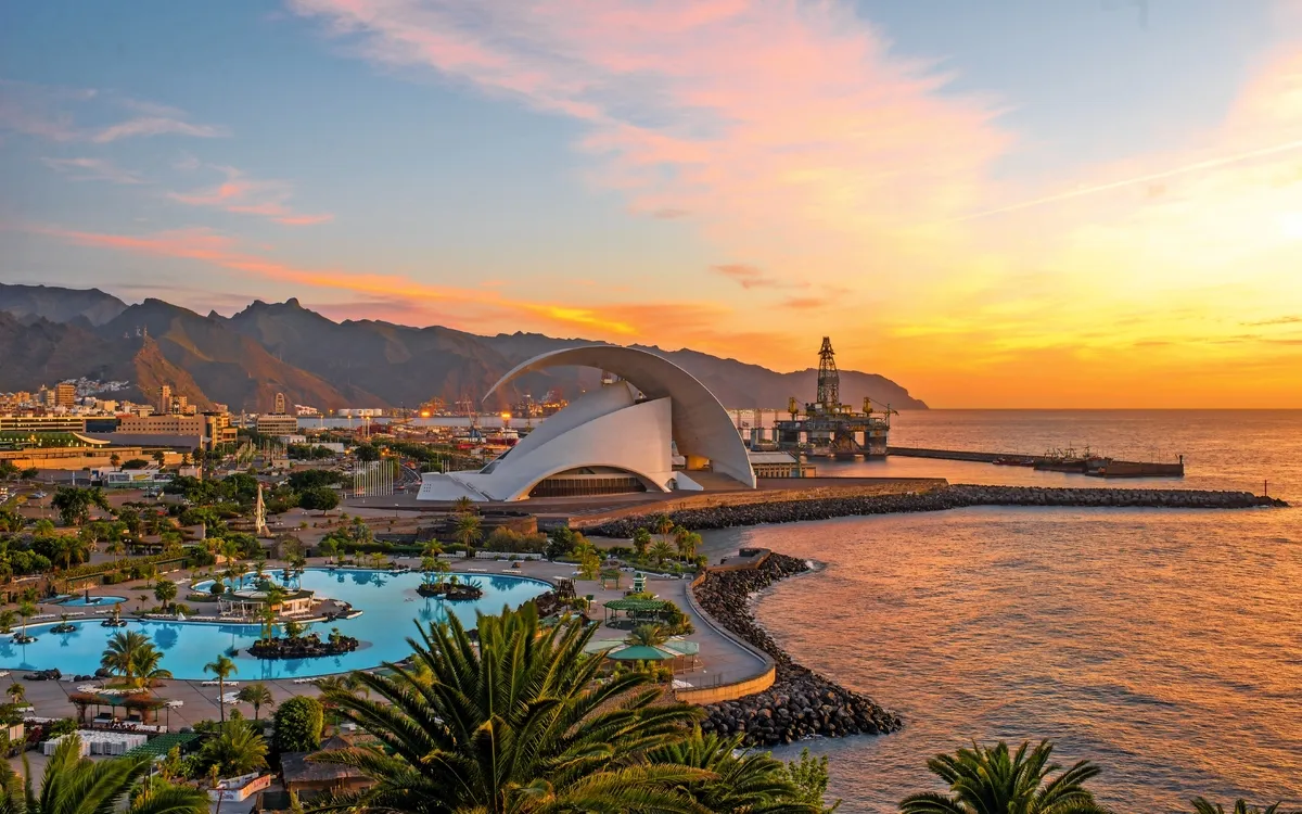 Hafen von Santa Cruz de Tenerife bei Sonnenuntergang mit Auditorio und Palmen.