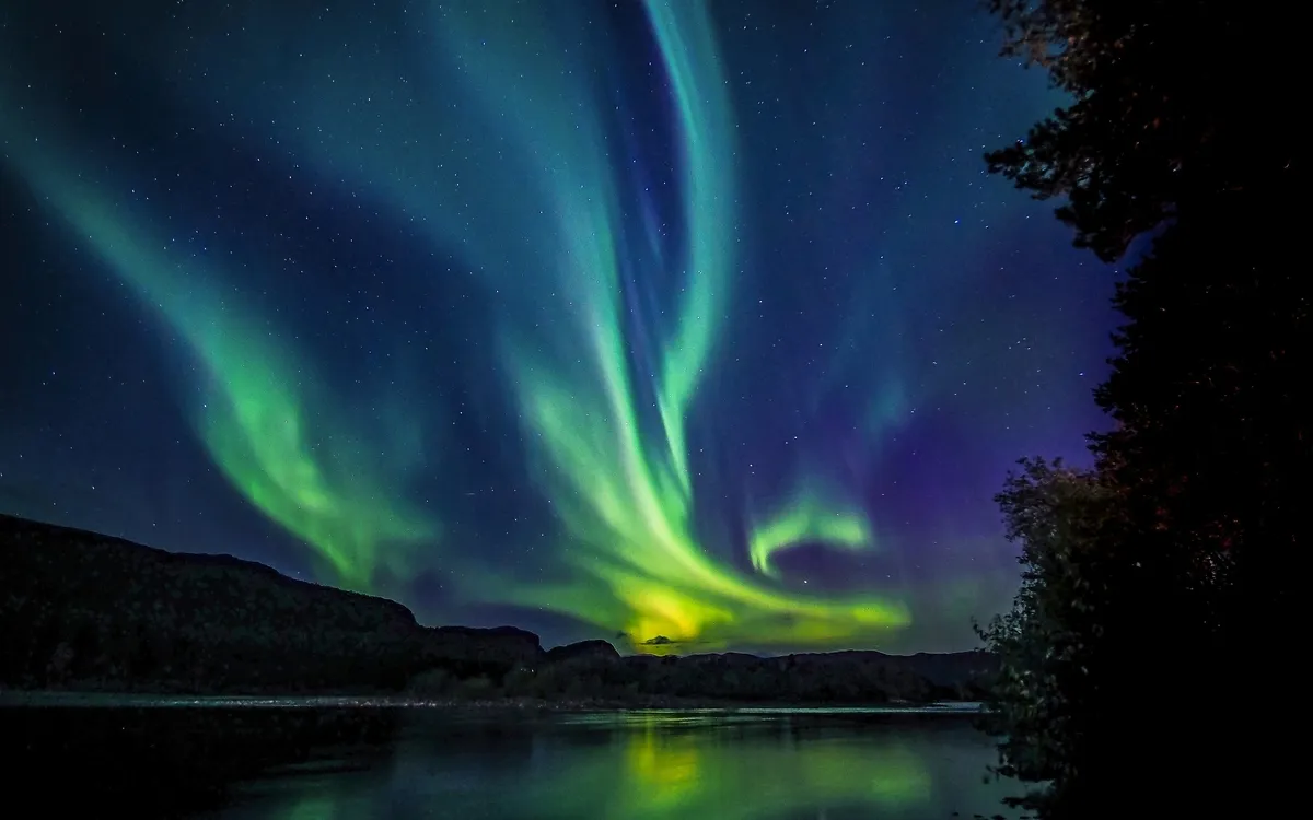 Nordlichter über einer norwegischen Landschaft am Nachthimmel