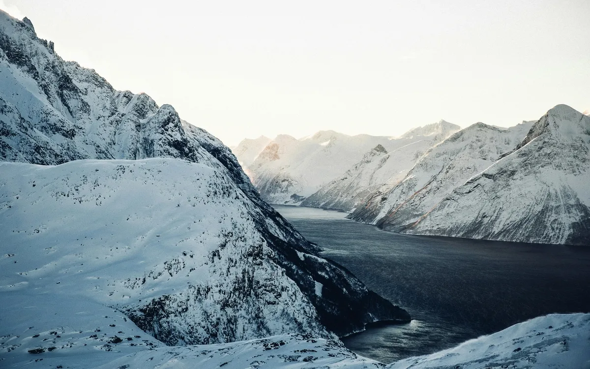 Verschneite Berge und Fjord in Ålesund
