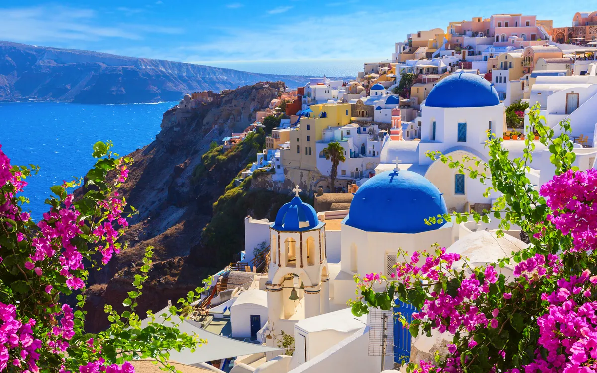 Griechisches Dorf mit blauen Kuppeln und Blick auf das Meer.