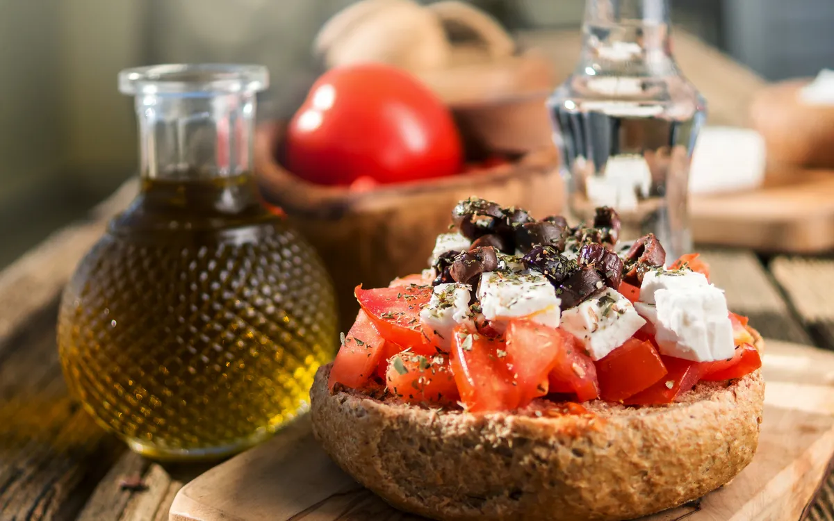 Kretisches Gericht mit Tomaten, Feta, Oliven und Olivenöl auf Brot.