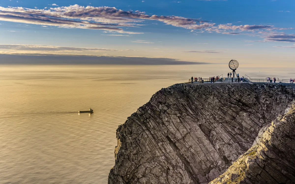Steilküste am Nordkap in Norwegen mit Globus-Skulptur im Hintergrund.
