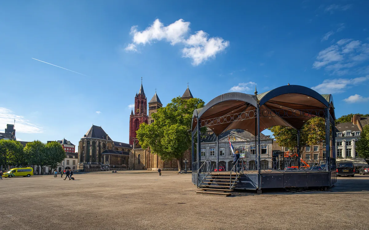 Ein leerer Platz mit Pavillon und historischer Kirche im Hintergrund.