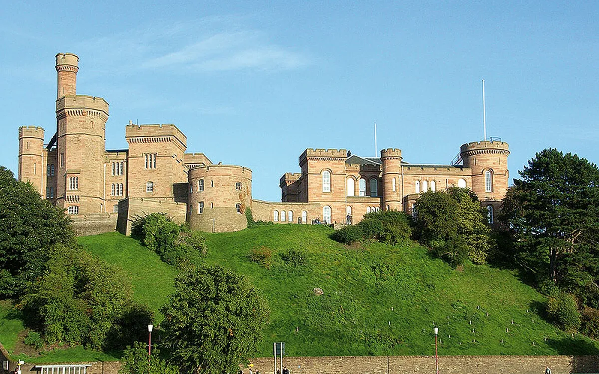 Burgschloss von Inverness mit Türmen und grüner Böschung.