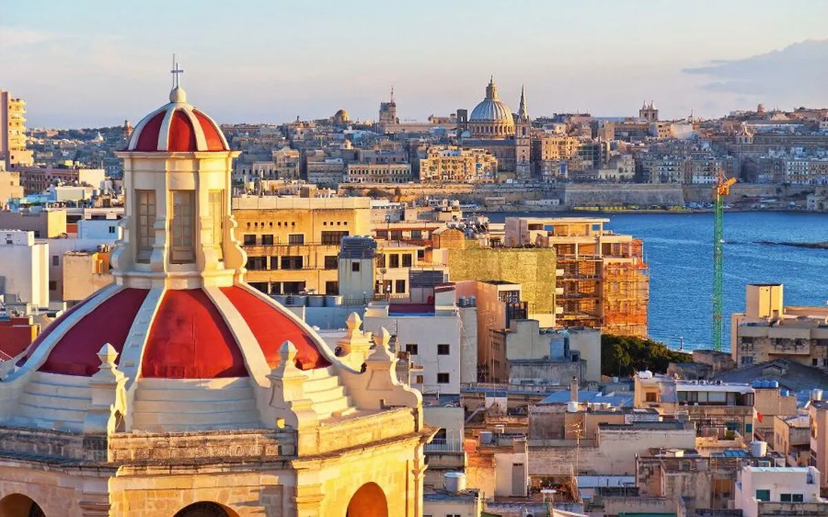 Stadtansicht von Valletta, Malta mit Kuppel im Vordergrund und Meer im Hintergrund.