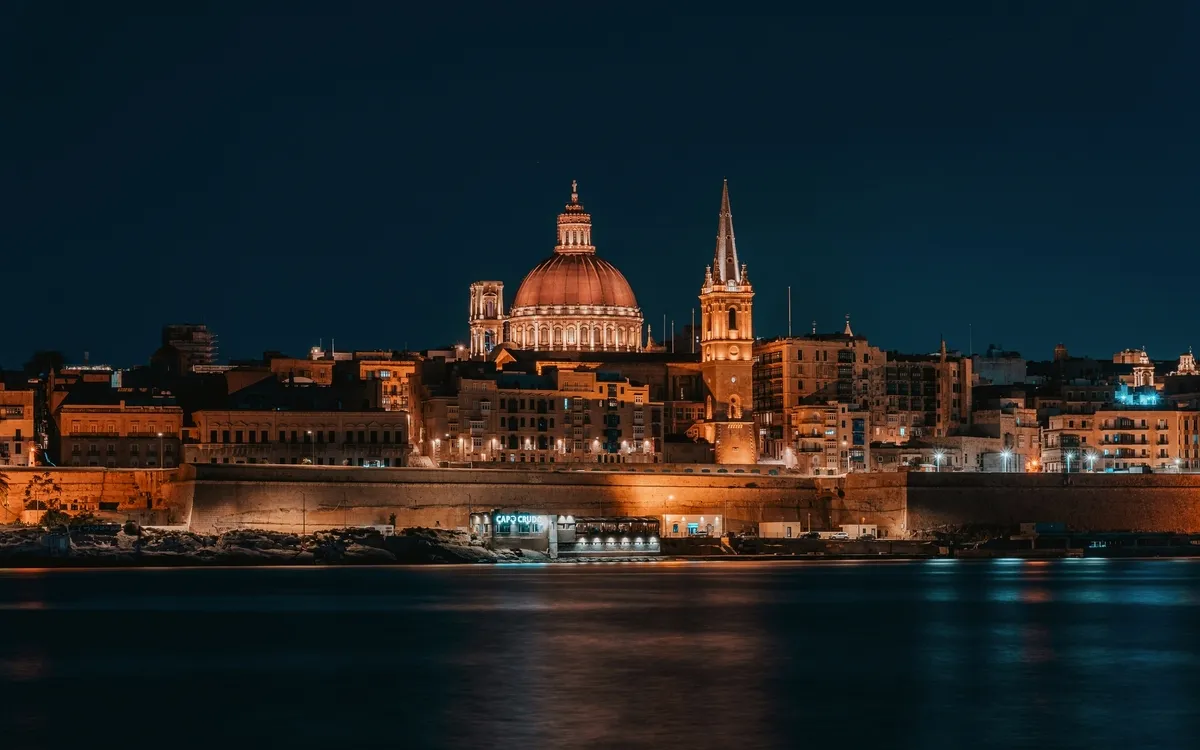 Blick auf die beleuchtete Innenstadt von Valletta, Malta bei Nacht.