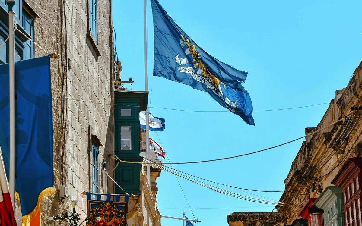 Straße in Mdina, Malta mit mehreren wehenden Flaggen.