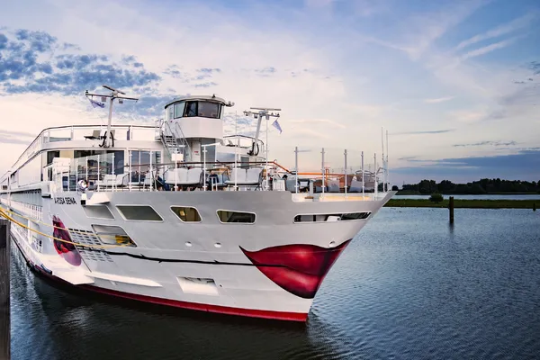 Kreuzfahrtschiff A-ROSA Sena auf dem Fluss Rhein bei Sonnenuntergang.