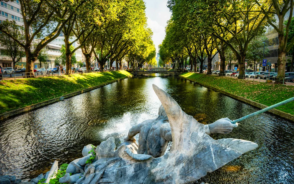 Königsallee in Düsseldorf mit Stadtgraben und Tritonenbrunnen – Sehenswürdigkeit bei einer Rheinreise