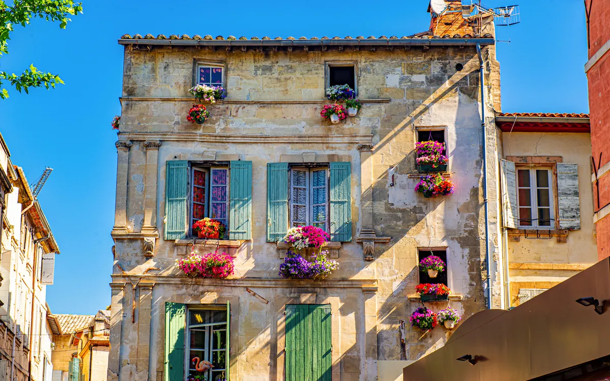 Historisches Haus mit Fensterläden und Blumen in Arles – Flusskreuzfahrt mit Frankenland Reisen