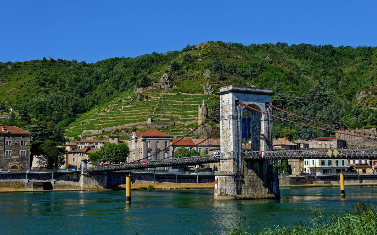 Hängebrücke über die Rhône in Tournon-sur-Rhône mit Weinbergen – Flusskreuzfahrt durch Frankreich